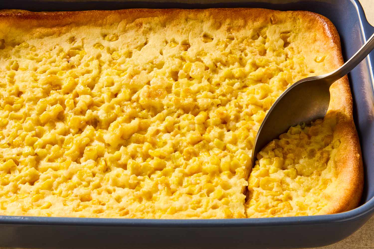 Corn soufflé with a spoon scooping out a serving