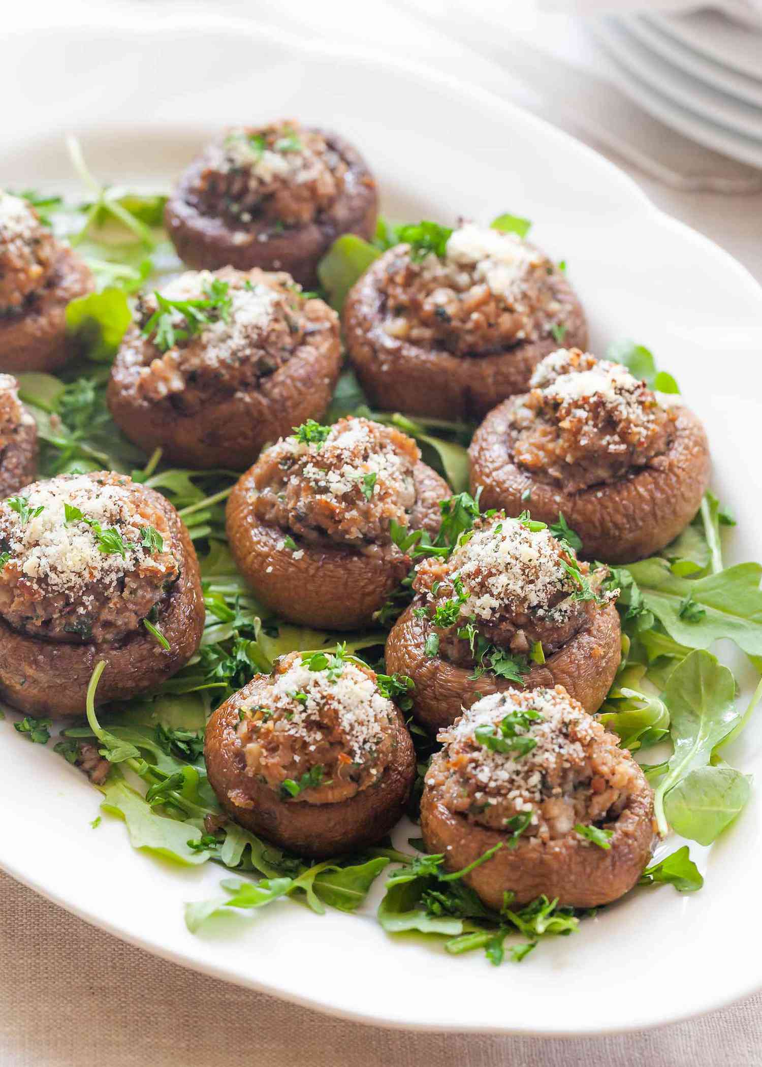 A platter of stuffed mushrooms on a bed of greens